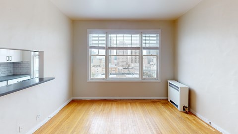 A room with a window and a radiator on the floor.