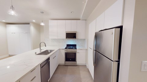A modern kitchen with white cabinets and a stainless steel refrigerator.