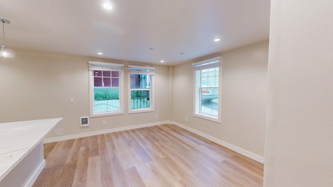 A room with wooden floors and two windows.