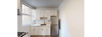 a kitchen with white cabinets and a stainless steel refrigerator