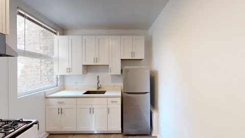 a kitchen with white cabinets and a stainless steel refrigerator