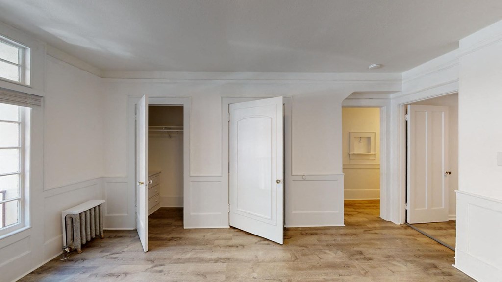 an empty room with four doors and a radiator