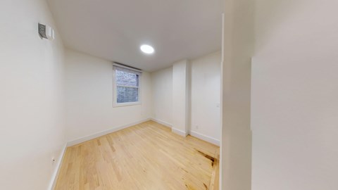 A room with wooden flooring and a window.
