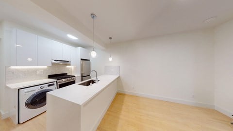 A modern kitchen with a washing machine built into the cabinetry.