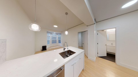 A kitchen with a white counter top and a sink.