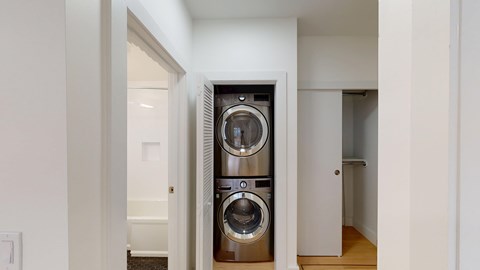 A modern laundry room with a washer and dryer built into the cabinetry.