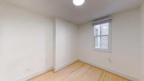 A room with a window and wooden floors.