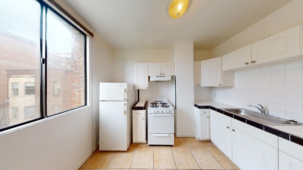 a kitchen with white appliances and a large window