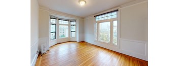 an empty living room with wood floors and windows