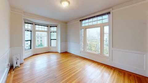 an empty living room with wood floors and windows