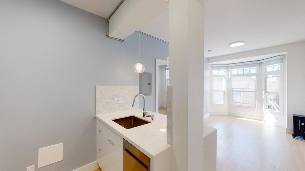 a white kitchen with a sink and a window