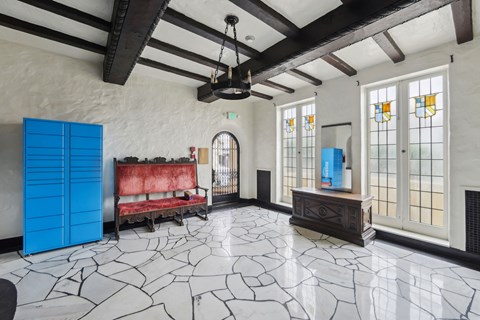 the living room has a large stone floor and a red couch