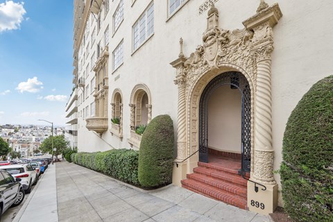 the side of a building with stairs and an arched doorway