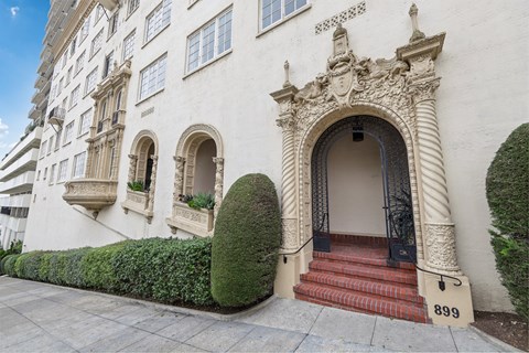 the exterior of a white building with stairs and a door