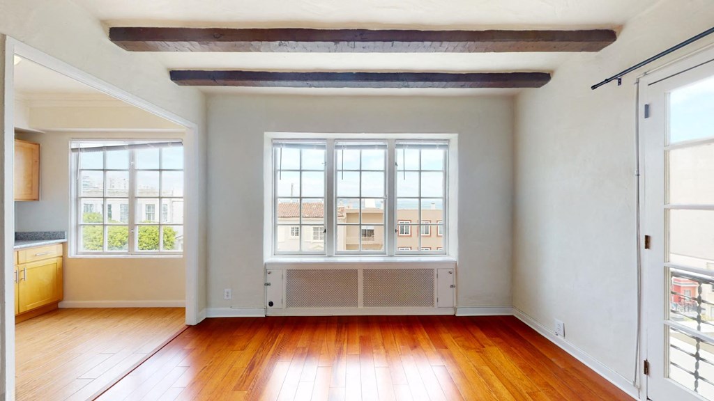 an empty living room with wood floors and windows