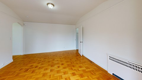 A room with wooden flooring and white walls.