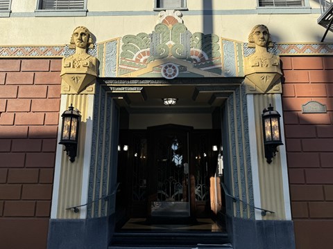 A building with a decorative entrance and two statues on top.