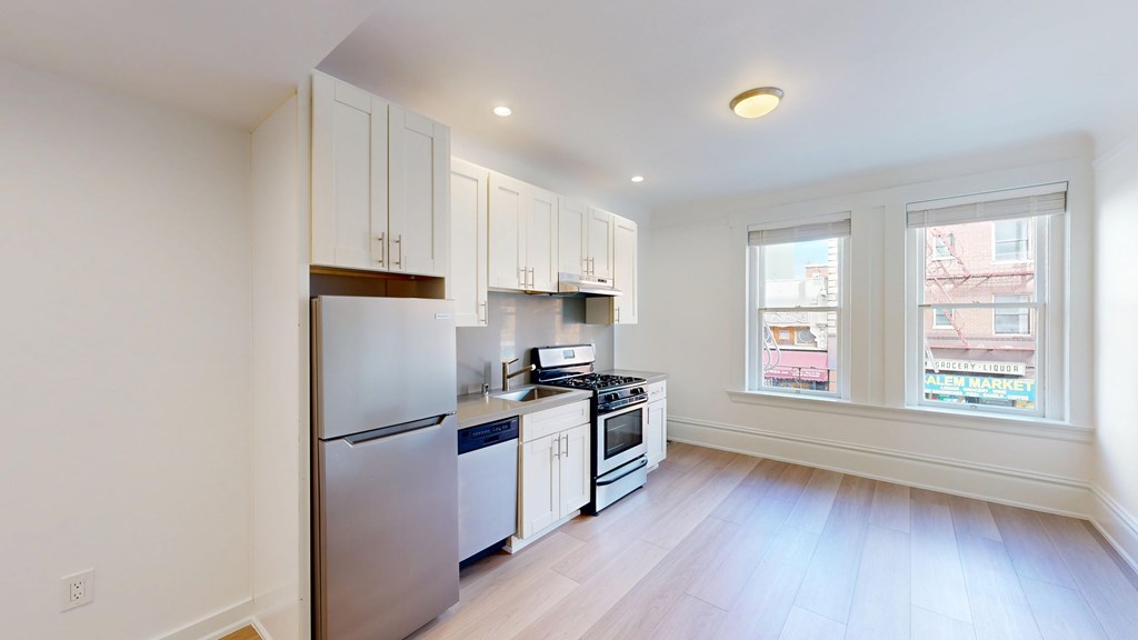 A kitchen with white cabinets and stainless steel appliances.