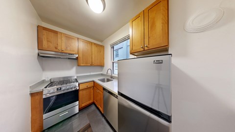 A kitchen with a stove, sink, and refrigerator.
