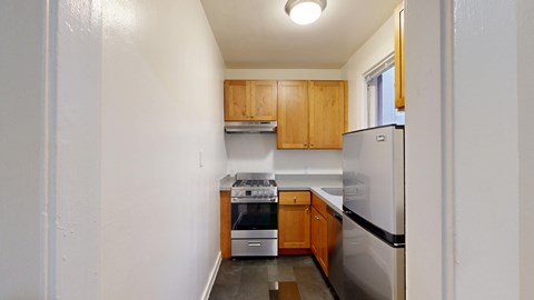 A kitchen with a refrigerator, oven, and cabinets.