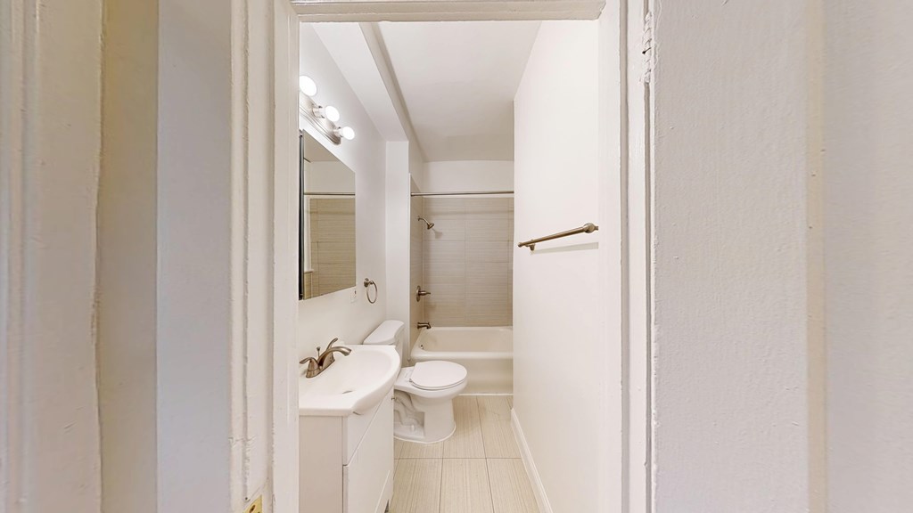 A white bathroom with a sink, toilet and mirror.
