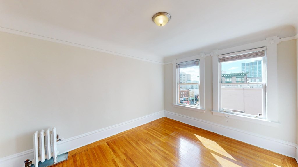 A room with a white wall and a wooden floor.