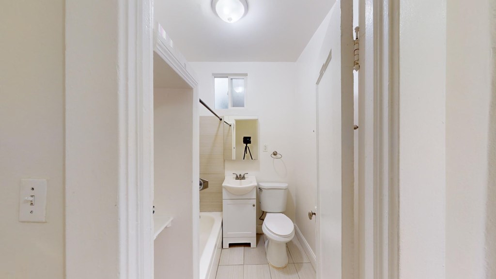 A white bathroom with a toilet, sink and bathtub.