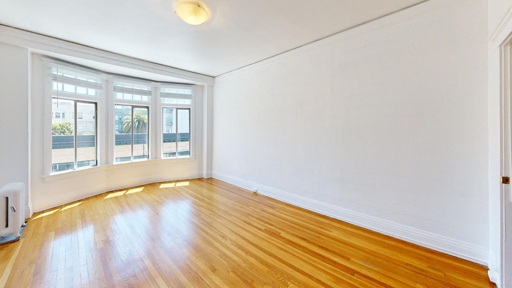 an empty living room with white walls and wood floors