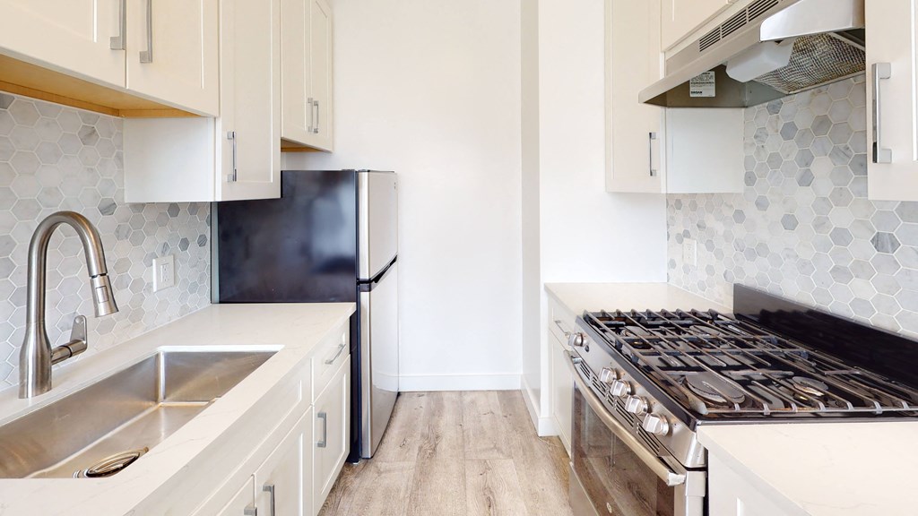 a kitchen with white cabinets and a stove and a refrigerator
