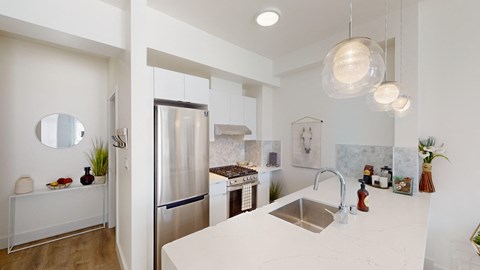 A modern kitchen with a stainless steel refrigerator and a white countertop.
