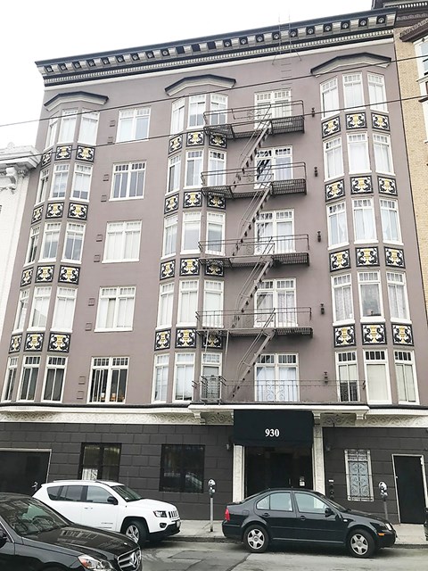 a tall building with cars parked in front of it