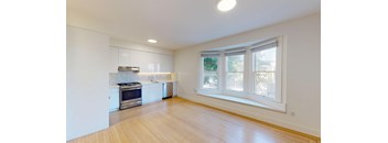 a kitchen with white cabinets and a large window