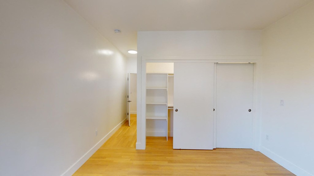 a room with white walls and a staircase and a closet