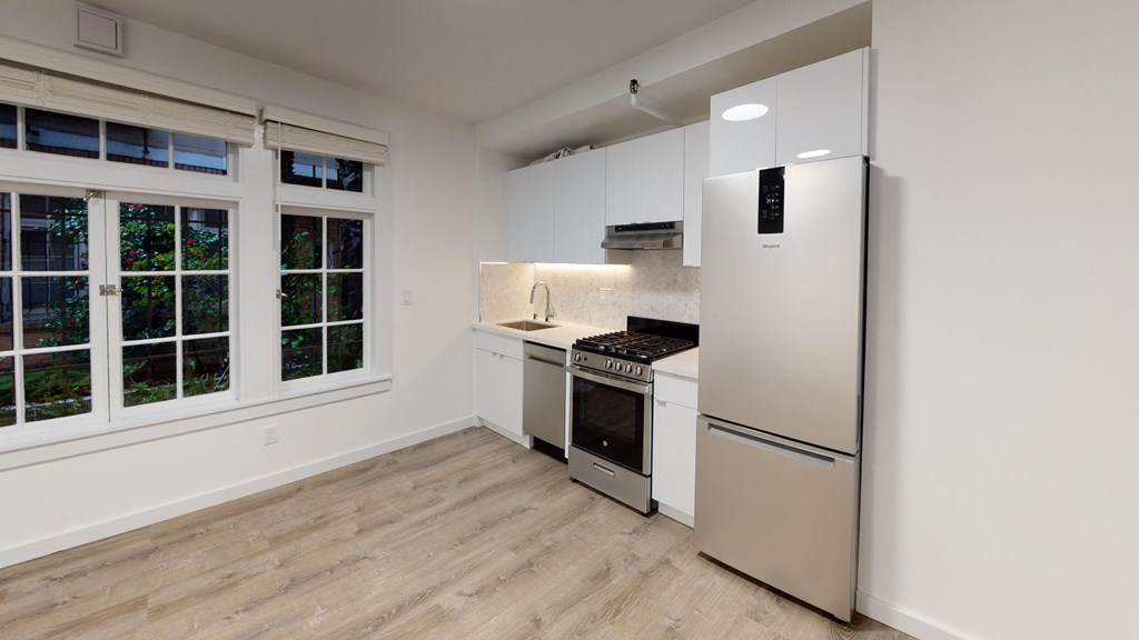 a kitchen with white cabinets and a stainless steel refrigerator