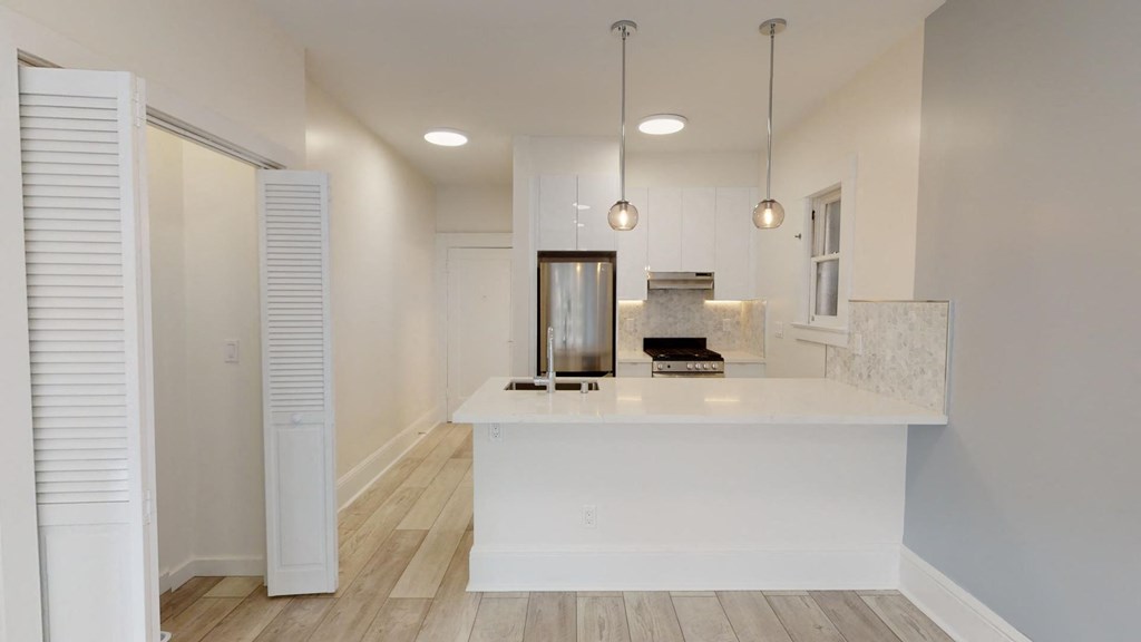 a white kitchen with a large island and white cabinets