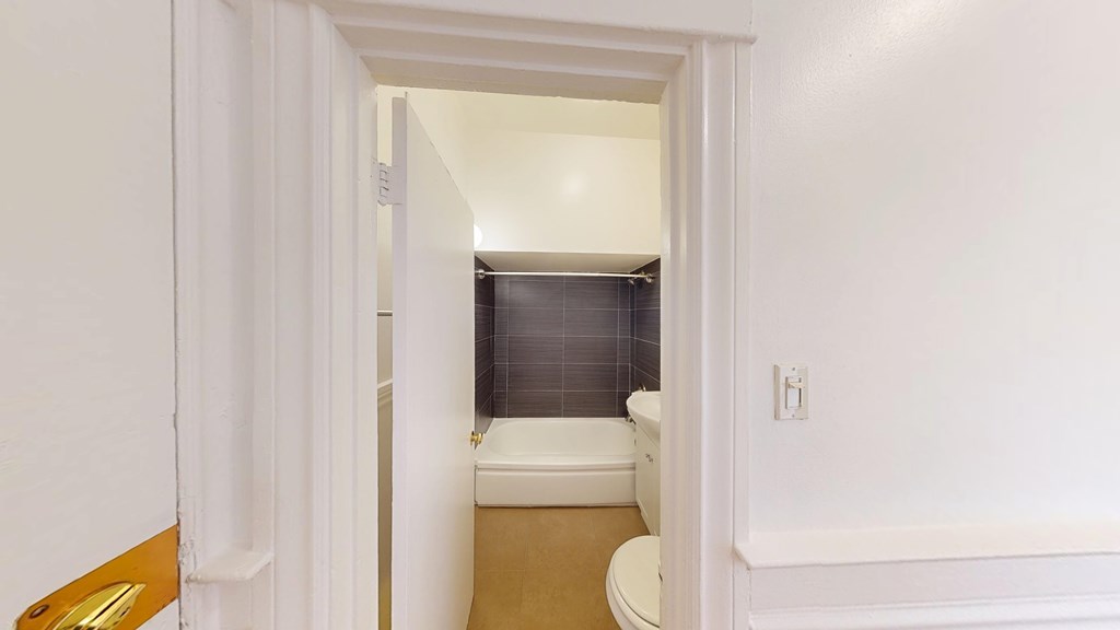 A white bathroom with a toilet and a shower.