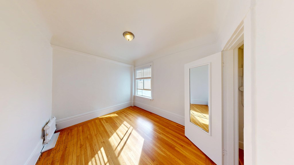 A room with wooden floors and white walls.