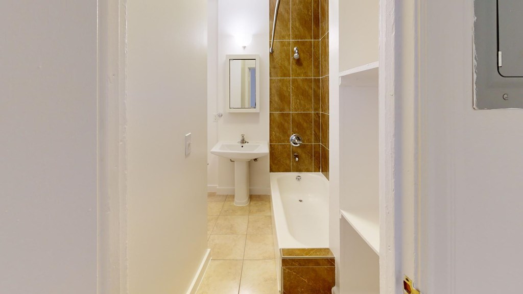 A white bathroom with a toilet, sink, and shower.