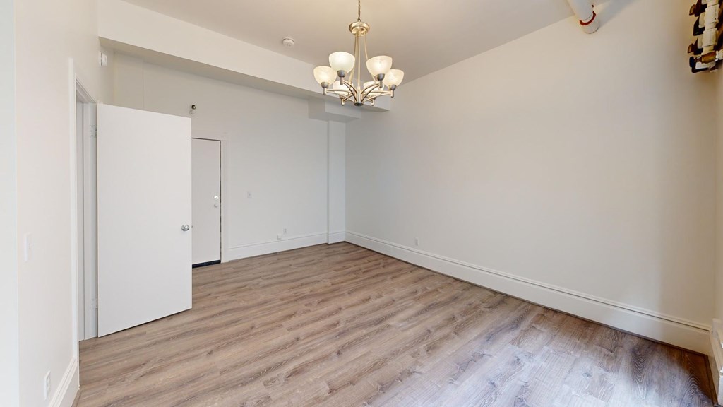 A room with a chandelier and a white door.