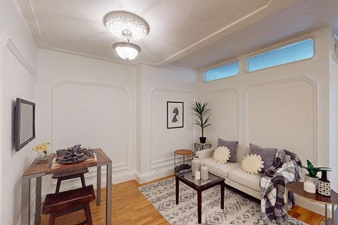 A living room with a couch, a table, and a chair.