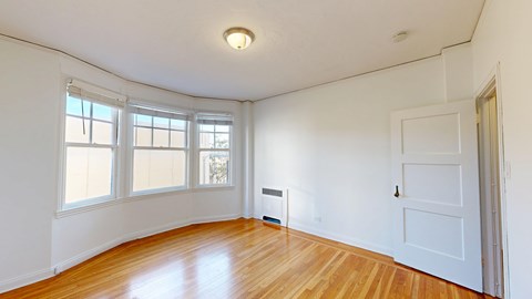 A room with a white door and a window with blinds.