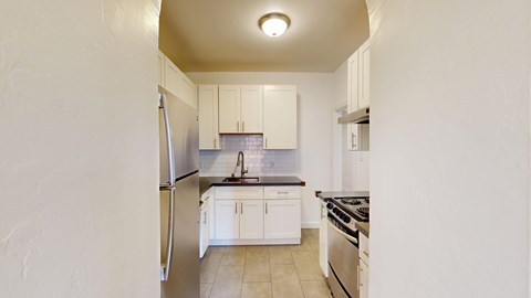 A kitchen with white cabinets and appliances.