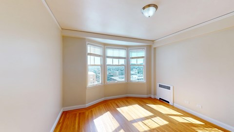 A sunny room with a view of the city through the windows.