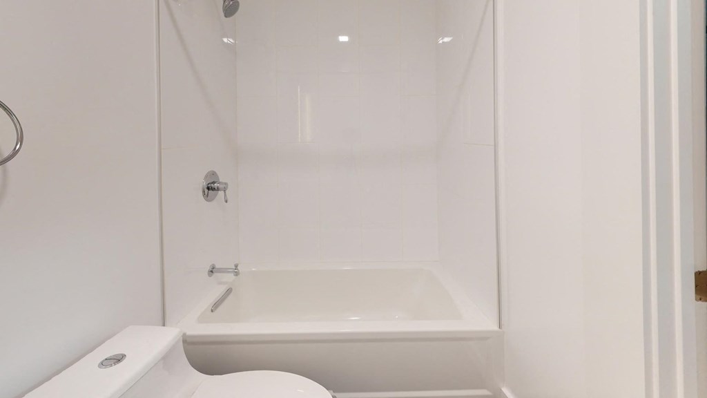 a white bathroom with a tub and a toilet