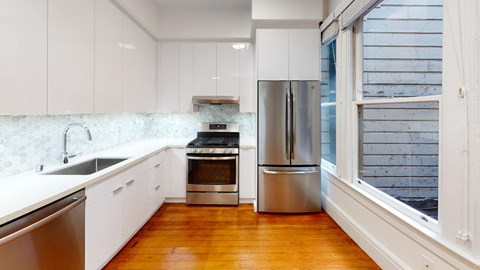 a kitchen with white cabinets and stainless steel appliances