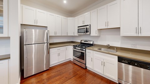 A kitchen with white cabinets and stainless steel appliances.