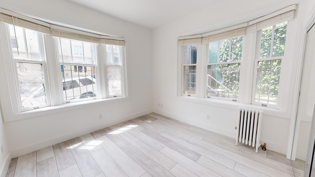 an empty room with three windows and a wood floor