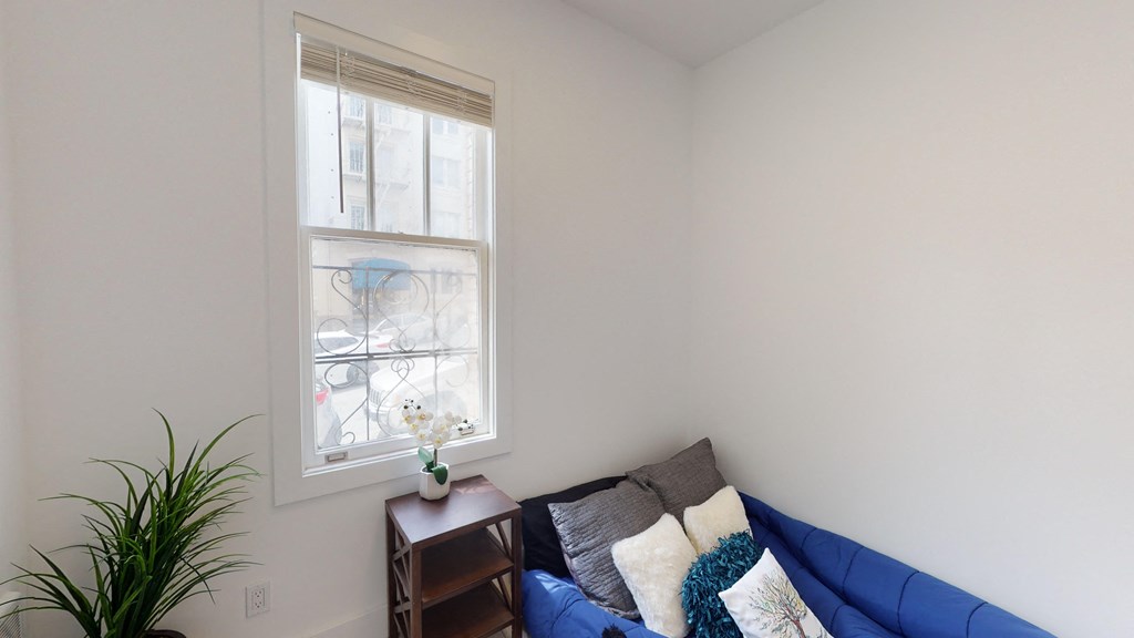 a living room with a blue couch and a window