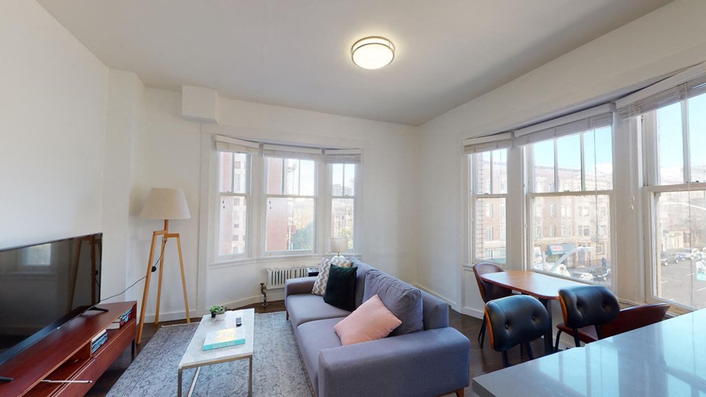 a living room with a couch and a table and some windows