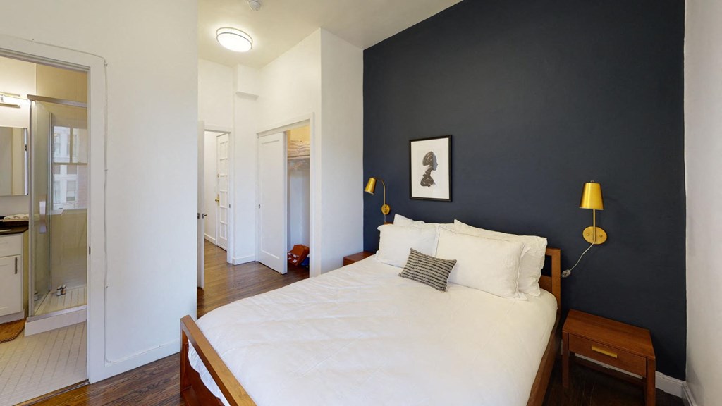 a bedroom with a white bed and a black wall